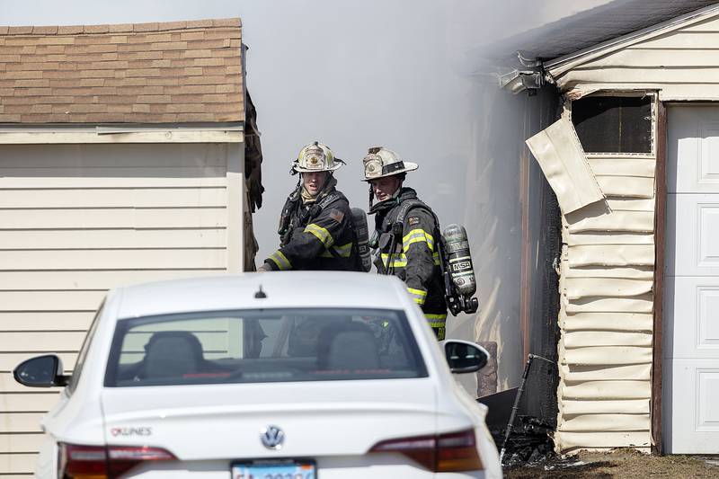 Firefighters work at the scene of a fire Friday, March 14, 2025, in Dixon. A backyard shed caught fire, damaging an adjacent garage and fence.