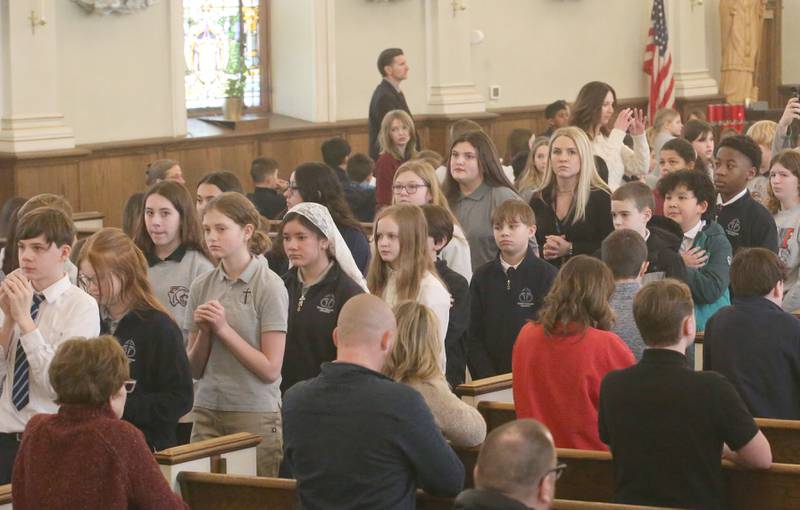Trinity Catholic Academy students receiver Holy Communion during an All Schools Mass on Thursday, Feb. 20, 2025 at St. Patrick's Catholic Church in La Salle. The bishop announced a new name for the three schools calling it Carlo Acutis. Last year, the Catholic Diocese of Peoria announced the consolidation of the three schools. Carlo Acutis Canonization will take place on Sunday, April 27, 2025 during the Jubilee of Teenagers in Rome. Acutis is the first millennial saint, representing those born between the early 1980's and the late 1990's. He is celebrated for cataloging miracles and online and managing websites for Catholic organizations.