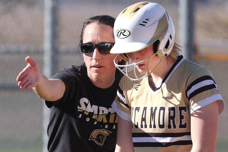 Sycamore head softball coach Jill Carpenter gives some instruction to Ema Durst at third base Monday, April 15, 2024, during their game against Rochelle at Rochelle High School.
