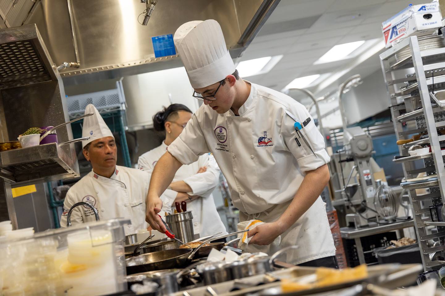 Joliet Junior College culinary arts program.  taken in 2023 of our then-student competition team during a practice. JJC PR said: I think they illustrate the action and dynamics of the training kitchens at City Center campus.