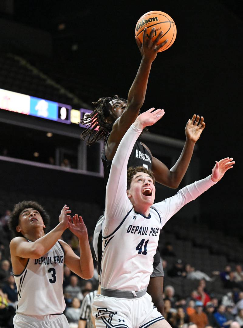 Kaneland's Freddy Hassan grabs a rebound over DePaul College Prep's Gus Donohue, front, and AJ Chambers during the Class 3A boys supersectional at NOW Arena on Monday, March 10, 2025 in Hoffman Estates.