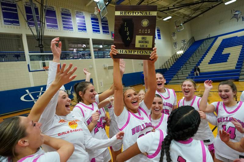 Batavia’s Natalie Warner (33) raises the regional championship plaque after defeating York to win a Class 4A Geneva Regional final basketball game at Geneva High School on Thursday, Feb. 20, 2025.