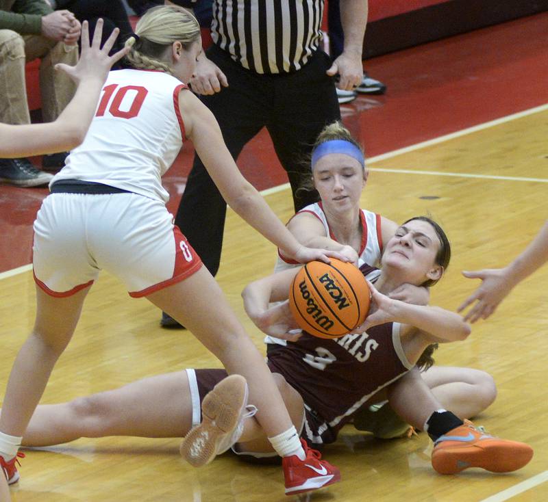 Ottawa’s Ella Schmitz and Skylar Dorsey battle with Morris’s Lily Hansen for control of a loose ball in the 4th period Saturday at Ottawa.