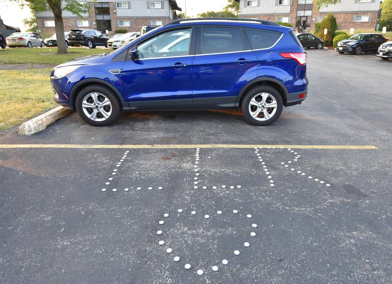 Residents on Monday spelled out LLR with candles, short for Long Live Reggie, near the scene where Reginald Meadows, 31, was killed in a mass shooting in Willowbrook during a Juneteenth celebration on Sunday morning, June 18, 2023.