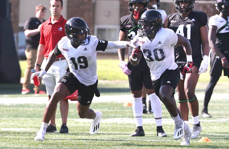 Northern Illinois University receiver Shemar Thornton (left) and running back Harrison Waylee take part in a drill Monday, August 1, 2022, during practice at Huskie Stadium in DeKalb.