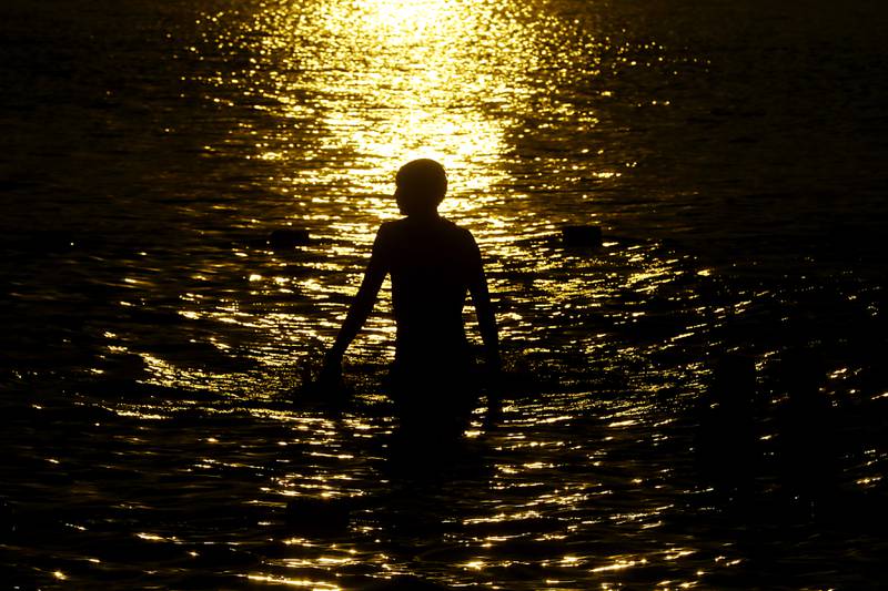 A boy plays in the waters of Crystal Lake before the start of the fireworks show Sunday, July 2, 2023, at Crystal Lake’s Main Beach during Crystal Lake Annual Independence Day Celebration.