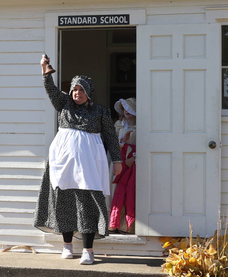 Southeast Elementary School third grade teacher Jami Sauber rings the bell to let the students know it’s lunch time Tuesday, Nov. 4, 2025, during a field trip to North Grove School, a one-room schoolhouse from 1878 in Sycamore.