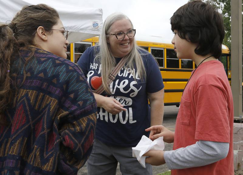 Northwood principal Bethany Hall talks with Ian Mejdouli and his mom, Tavena, during a Woodstock School District 200 Back to School Coming to You event at Sheila Street Apartments on Tuesday, Aug. 6, 2024. The location was one of twelve stops on the tour that gave out backpacks and school supplies, provided registration help and computer repair.