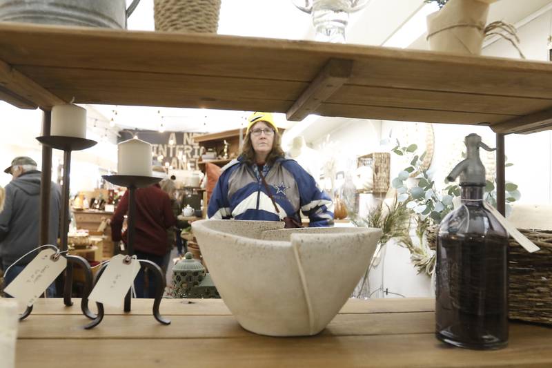 Sally Moss shops at A New Interiors Anew during the Lighting of the Square event Friday, Nov. 25, 2022, in Woodstock. The annual event featured brass music, caroling, free doughnuts and cider, food trucks, festive selfie stations and shopping.