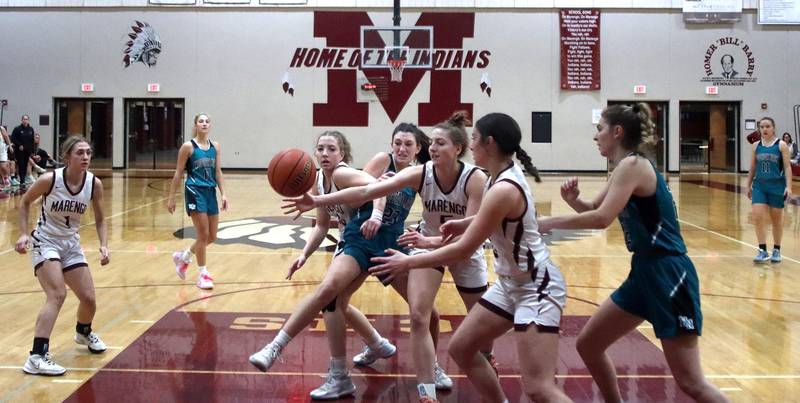 Marengo and Woodstock North players scramble under the hoop in girls basketball at Marengo on Thursday.