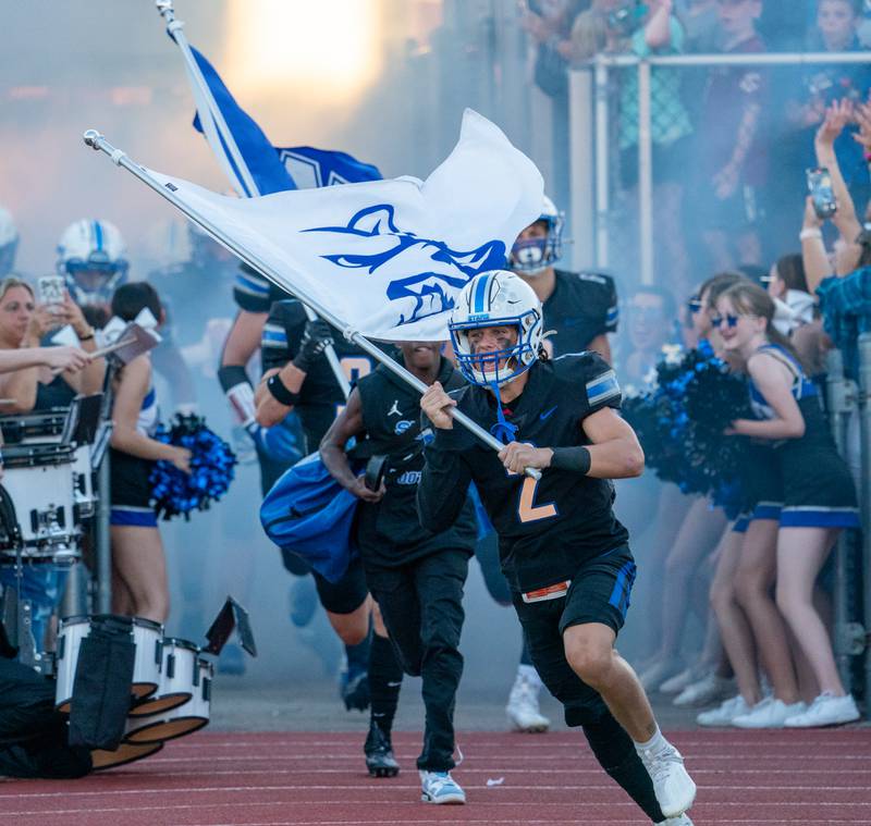 St. Charles North's Brody Geary (2) leads his team to field prior to the start of their football game against Lake Zurich at St. Charles North High School on Friday, Sep 2, 2022.