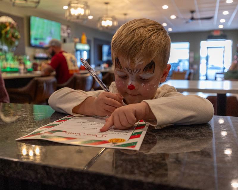 Riley Waynick writes letter to Santa at the annual Christmas in the Valley on Saturday, November 15, 2025 at the Tee Box in Spring Valley.