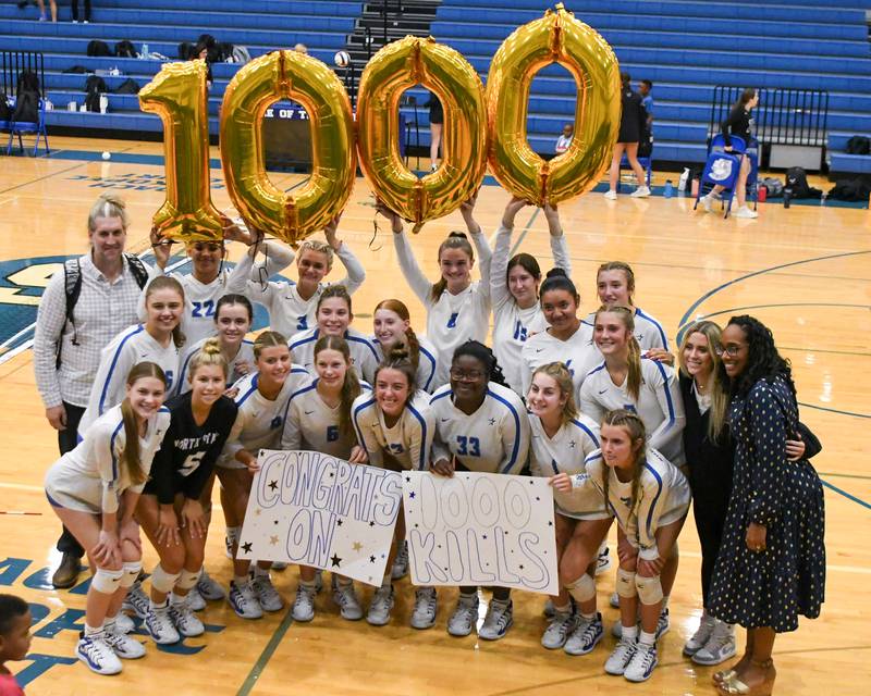 St. Charles North’s volleyball team poses for a photo as Haley Burgdorf, front row center, made her 1,000 kill during the game while traveling to take on St. Francis High School in Wheaton.