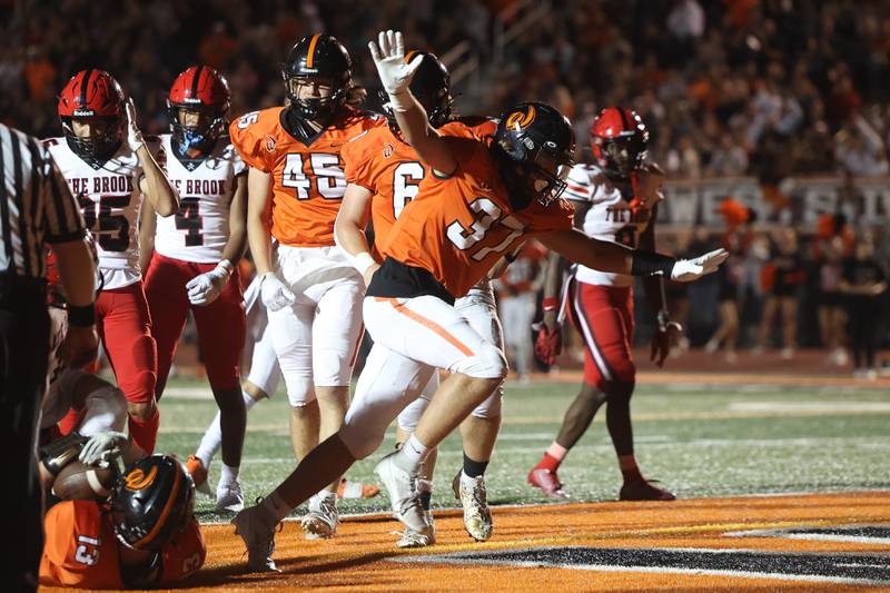 Lincoln-Way West’s Noah Wendt celebrates after giving Joey Campagna an extra push for the touchdown run against Bolingbrook on Friday, Sept. 22 in New Lenox.