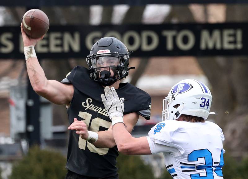 Sycamore's Burke Gautcher throws a pass just before the hit by St. Francis' Will Alt Saturday, Nov. 16, 2024, during their Class 5A quarterfinal game at Sycamore High School.