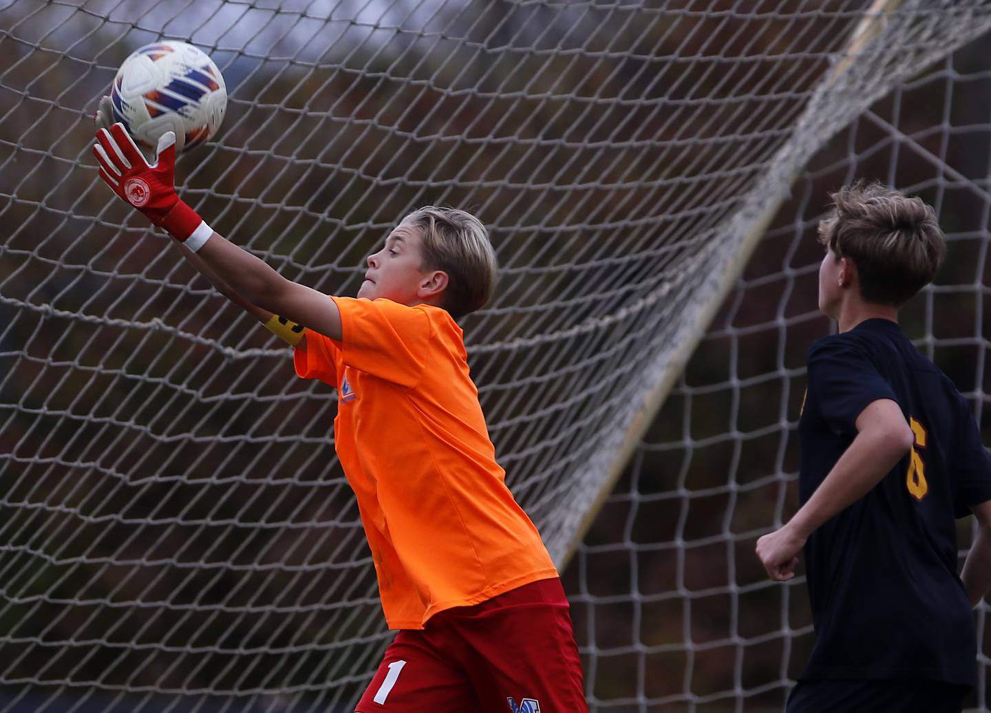 Marian Central's Dustin Emmert makes a save in front of Richmond-Burton's Brayden Mumbower during the IHSA Class 1A Marian Central Regional Boys Soccer Final match on Tuesday, Oct. 22, 2024, at Marian Central High School in Woodstock.