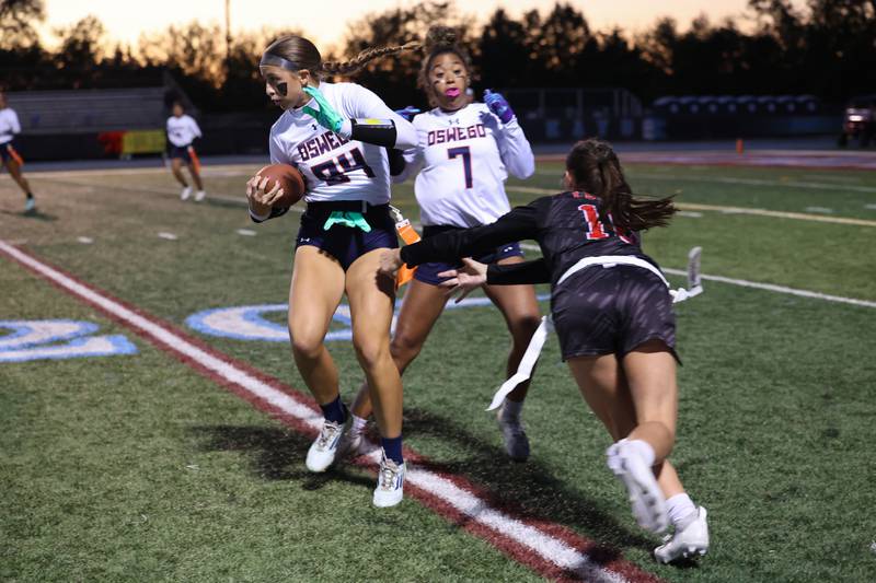Oswego's Sophie Augustine runs the ball as Yorkville's Hayden Hodges goes for her flag during the Foxes 2-1 overtime victory over Oswego in the IHSA Kankakee Regional championship game on Thursday, Oct. 9, 2025.