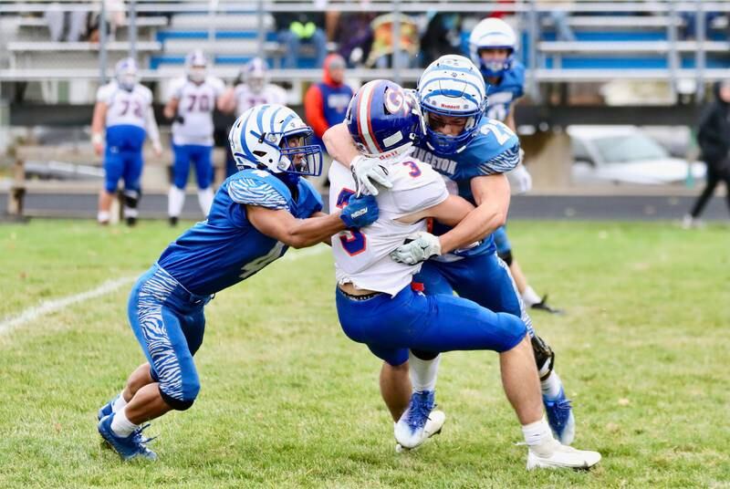Princeton's Andrew Peacock (4) and Carson Etheridge (23) take down Genoa-Kingston's Brody Engel in Saturday's 3A Playoff at Bryant Field.