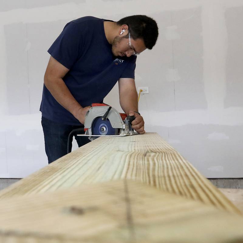 Jose Campos, a senior in the Woodstock Building Trades Program, uses a circular saw as he builds stairs Monday, May 8, 2023, at the home students are building in Woodstock. This will be the program’s 43 completed home since it began in 1972.