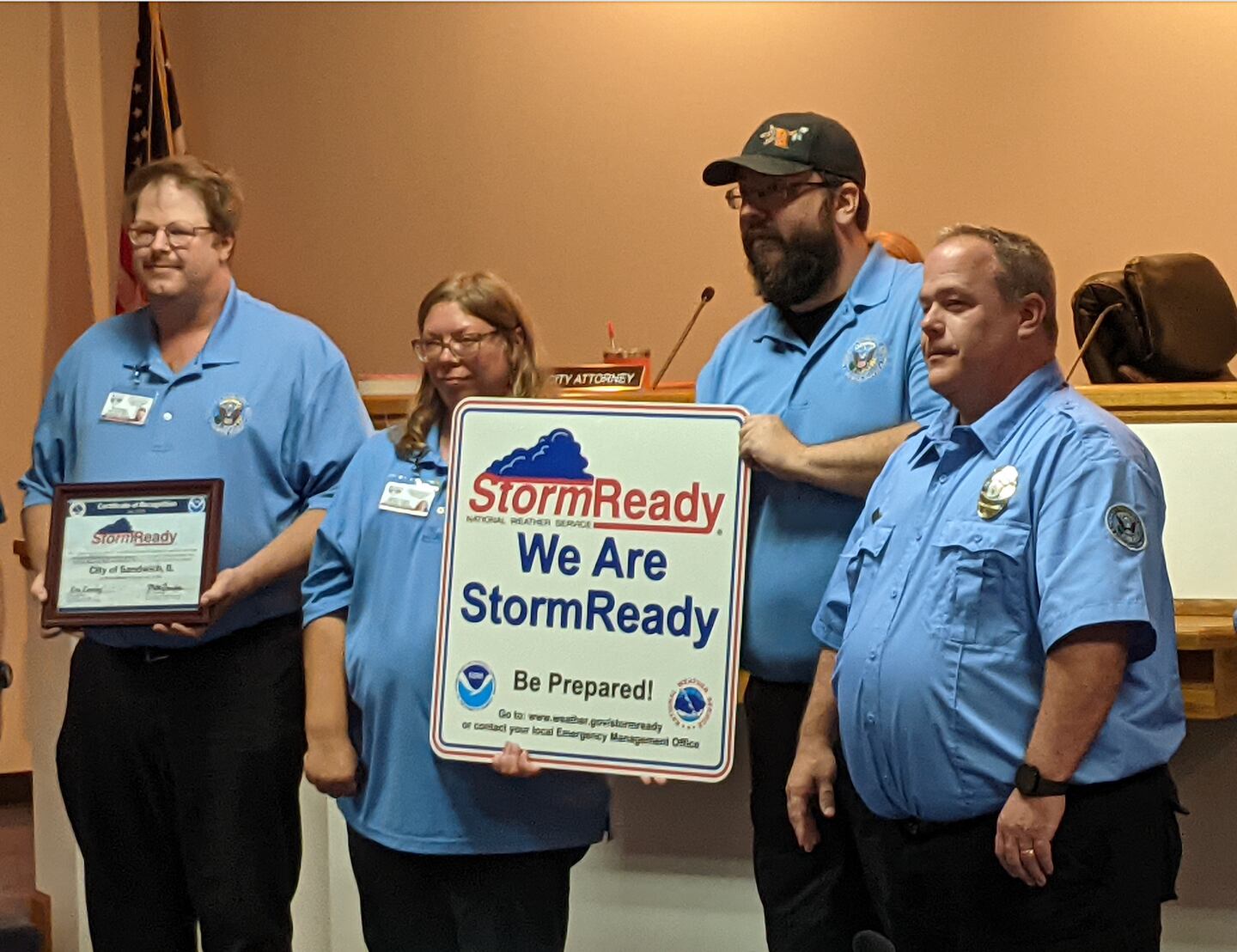 Sandwich Illinois Emergency Management Agency Assistant Director Tim Keierleber, far left, SEMA volunteer Caroline Thomas, SEMA volunteer Don Schroeder and Sandwich Illinois Emergency Management Agency Director Tony Eberle, stand next to a sign designating Sandwich as a National Weather Service StormReady community.