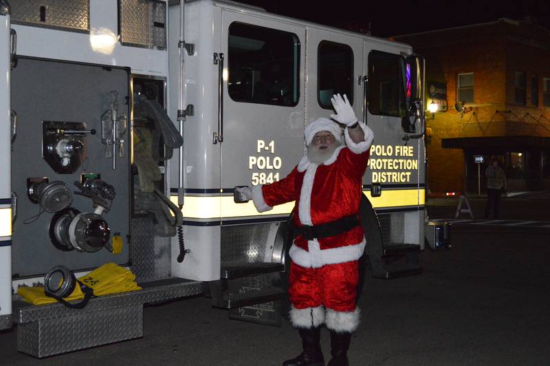 Santa Claus waves to onlookers after arriving in downtown Polo on Dec. 4. Santa and Mrs. Claus stopped by as part of the third annual Polo Christmas Festival.