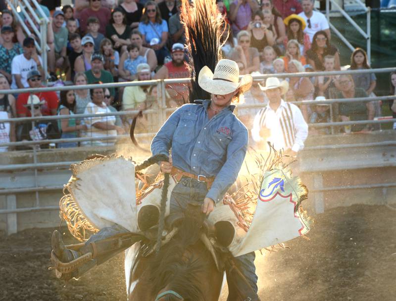 Cole Hedge tries to stay on a bucking bronco during the T and A rodeo at the Lee County Fair on Saturday, July 29, 2023.