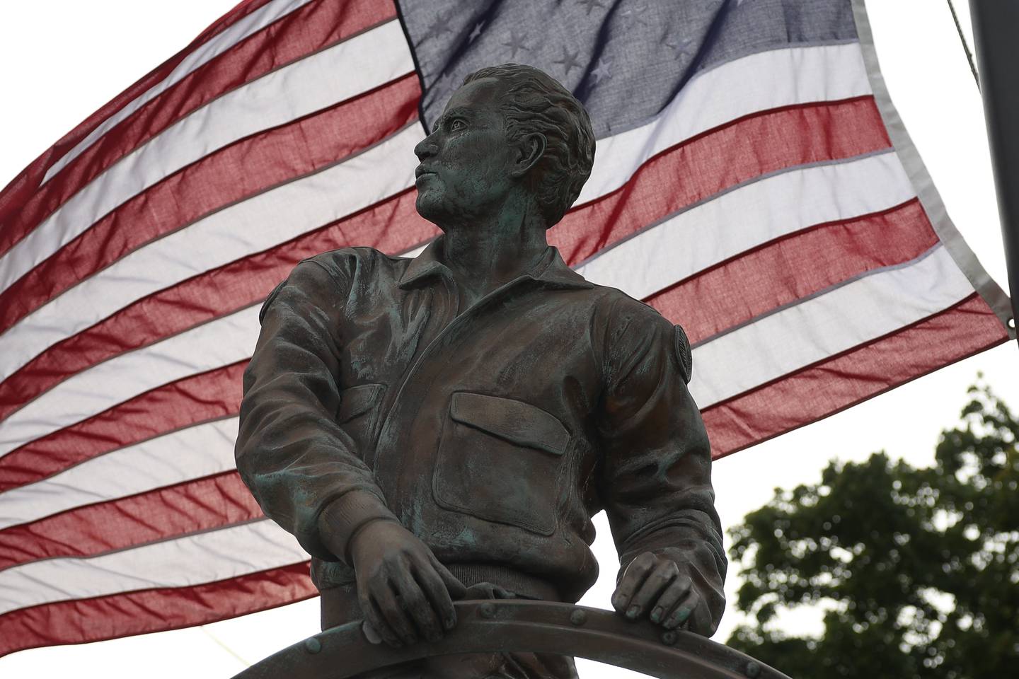 An American flag flies behind the Sator Sanches statue at the corner of Collins and Ohio Street on Friday, Sept. 27, 2024.