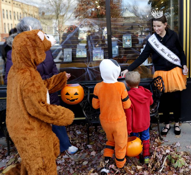 Gia Galli, the 2024 Little Miss Woodstock, hands out candy to trick or treaters during Halloween on the Square on Thursday, Oct. 31, 2024, in Woodstock. The event featured trick and treating and a costume contest.