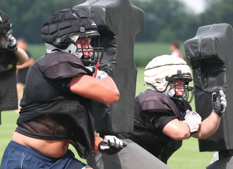 Kaneland’s Jake Buckley hits the blocking sled Monday, Aug. 18, 2025, during practice at the school in Maple Park.