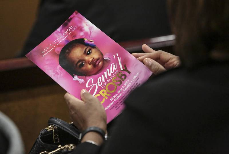 A mourner holds a program Friday, May 5, 2017, during the funeral for Sema'j Crosby at Prayer Tower Ministries Church of God In Christ in Joliet, Ill.