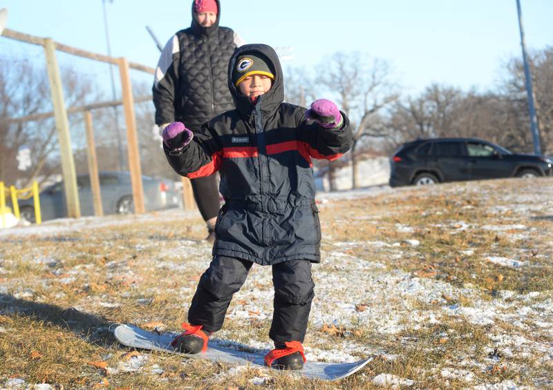 Silas Orellana, 8, of Naples, Florida, balances on his snow board as he glides down the hill at Winter Park in Morrison on Friday, Jan. 3, 2025. Silas and his family were visiting relatives in Morrison and wanted to try sledding following the dusting of snow that fell across the region.