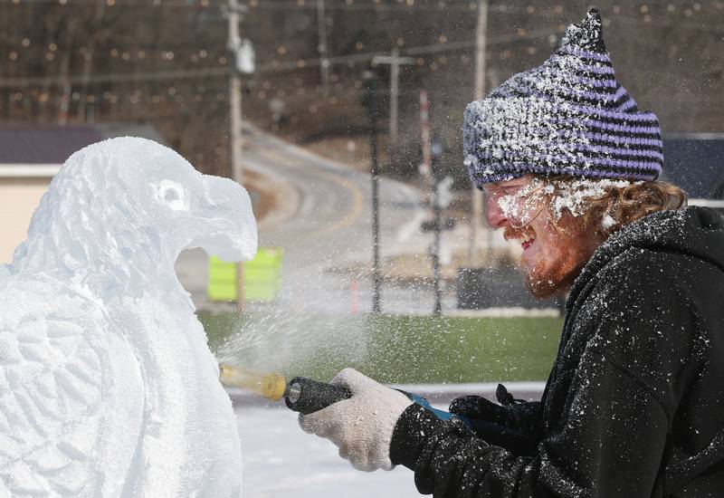 Isiah Troxel of Chicago, carves a Bald eagle out of a block of ice at the Market on Mill area on Saturday, Jan. 25, 2025 downtown Utica. Johnson Studios Ice Sculptures of Chicago made three eagle carvings for the villlage during Eagle Watch Weekend at Utica and Starved Rock State Park.