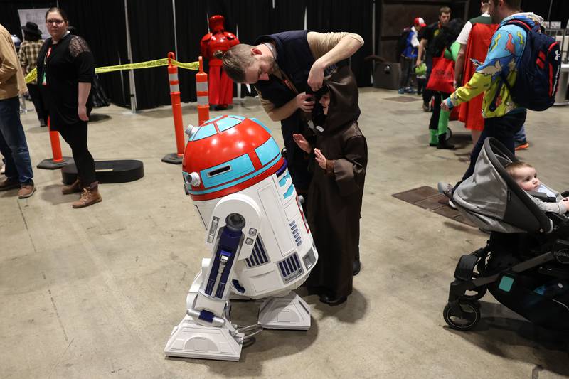 Adam Weiss, of Chicago, fixes his daughter’s Star Wars Jedi costume before taking a photo with a droid at C2E2 Chicago Comic & Entertainment Expo on Friday, March 31, 2023 at McCormick Place in Chicago.