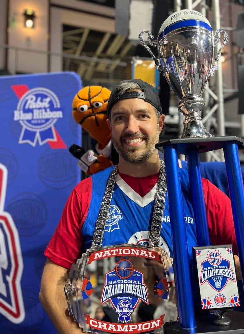 Marseilles native Josh Caputo, now of Montgomery, displays the medallion and trophy he earned by winning the National Pop-A-Shot Tournament in Rick Hill, South Carolina.
