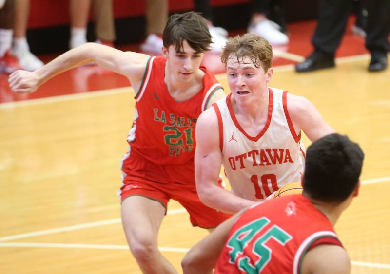 Ottawa's Evan Snook cuts in the lane between L-P's Wyatt Kilday and teammate Andy Medina on Friday, Jan. 10, 2024 in Kingman Gym at Ottawa High School.