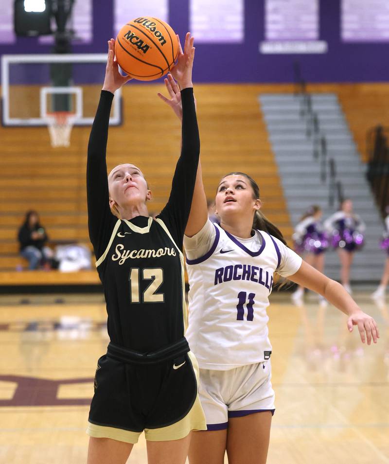 Sycamore's Sadie Lang grabs a rebound in front of Rochelle's Audrina Rodriguez Friday, Dec. 5, 2025, during their game at Rochelle High School.