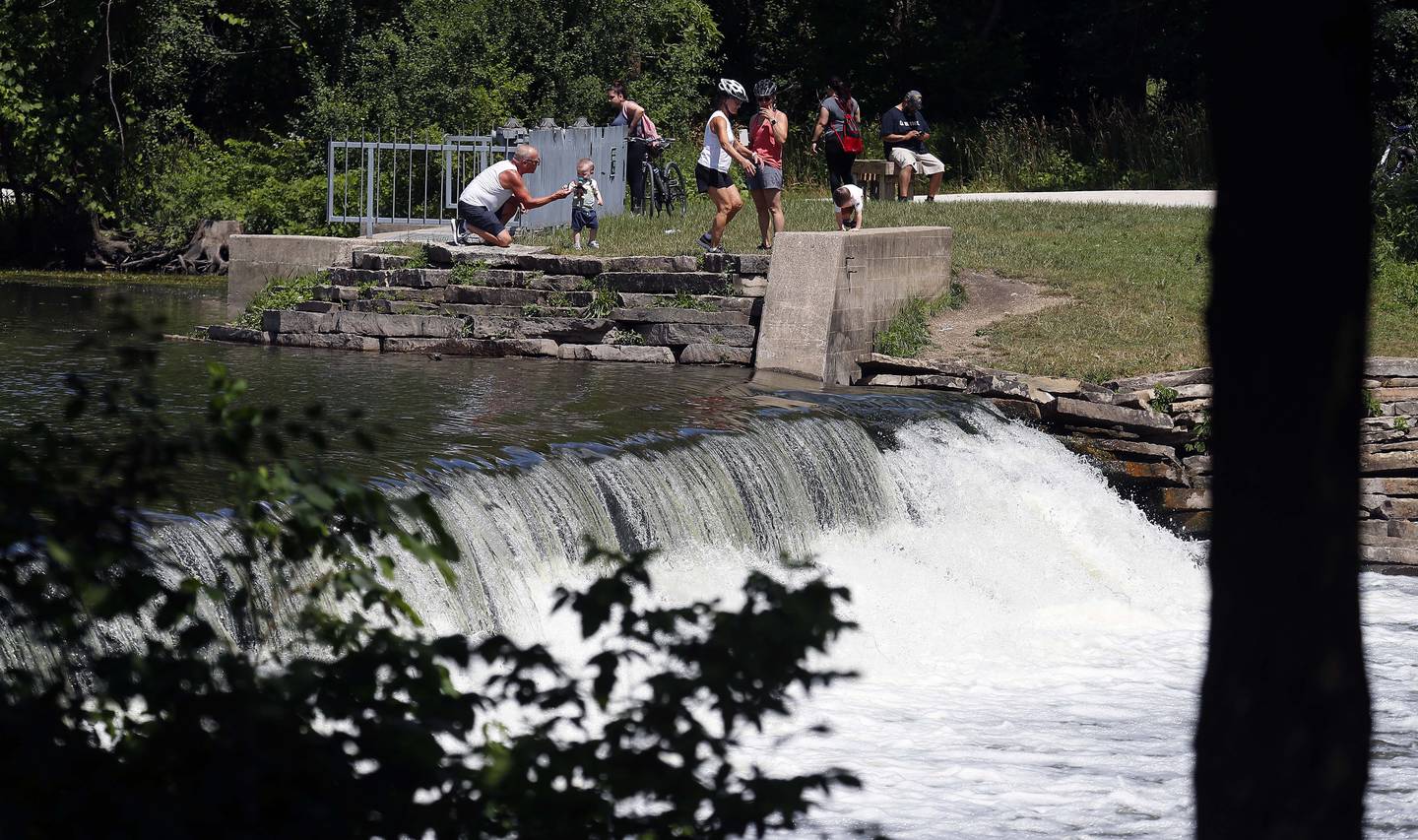 People gather near the old Graue Mill dam at Fullersburg Woods in Oak Brook