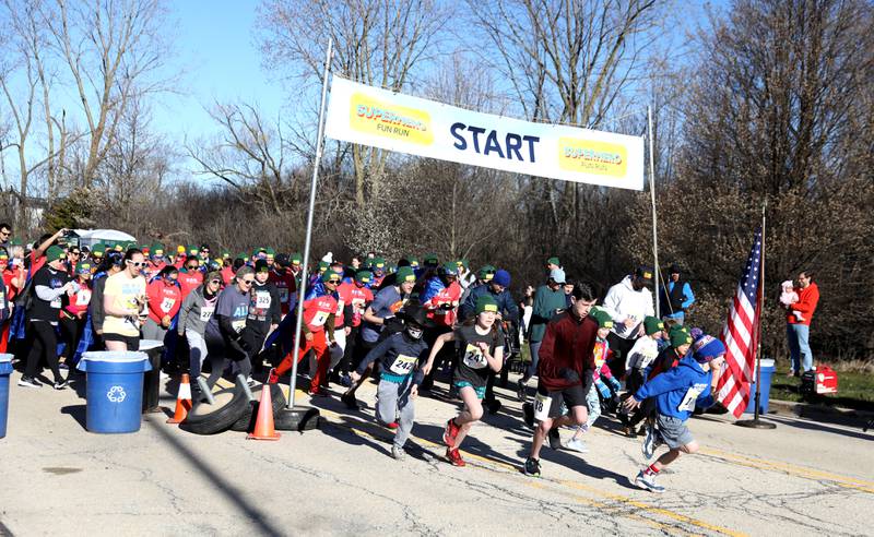 Runners take off at the start of the Wheaton Park District’s Superhero 3K Fun Run at the Sensory Garden Playground in Lisle on Saturday, April 6, 2024.