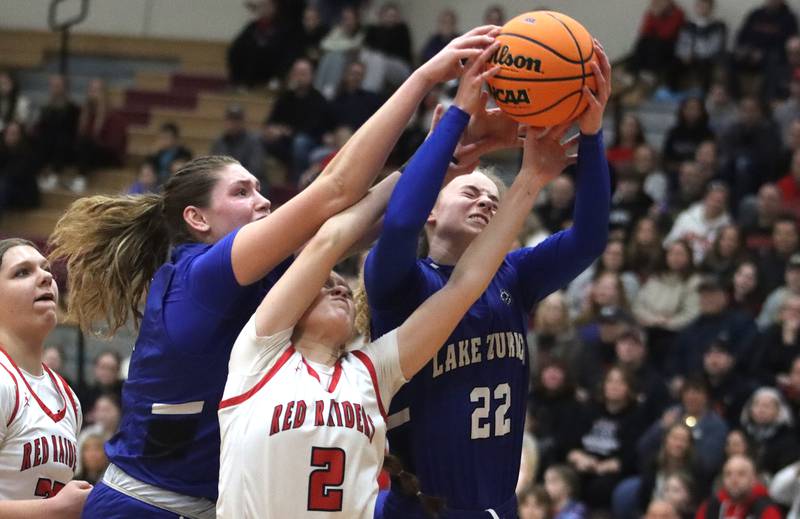 Huntley’s Avery Suess, center, battles Lake Zurich’s Alex Nowak-Tice, left, and Avery Cooper, right, for the ball in IHSA Class 4A Sectional girls basketball action on Tuesday, Feb. 25, 2025, at Huntley High School in Huntley.