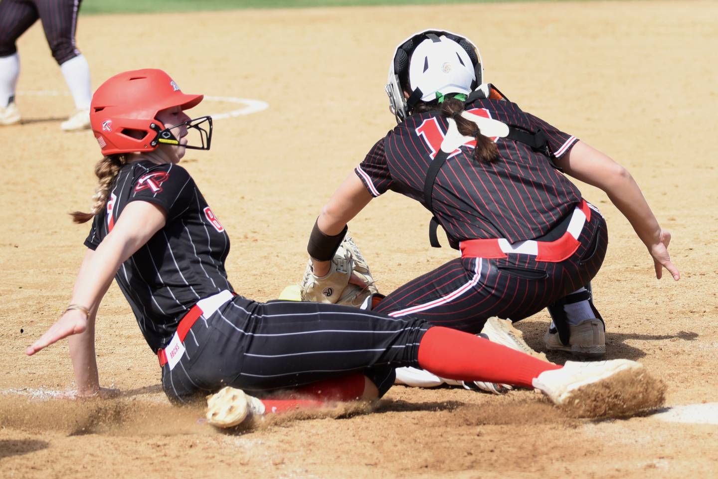 Bradley-Bourbonnais' Elise Munsterman, left, slides in for a run as Marist catcher Alexis Kyros fields a throw at home during a game at Bradley-Bourbonnais Saturday, March 21, 2026.