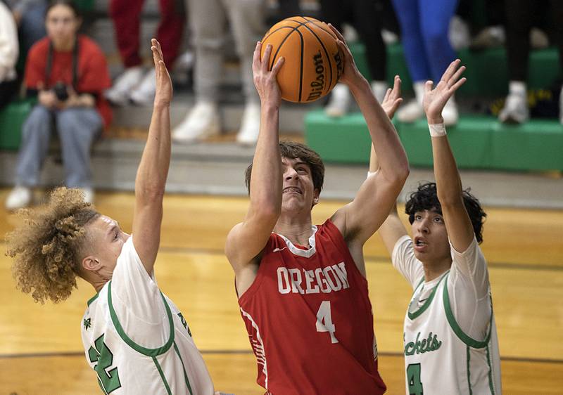 Oregon’s Jackson Caposey puts up a shot against Rock Falls’ Nehemiah Menendez (left) and Rock Falls’ Christian Hernandez Friday, Jan. 10, 2025 at Rock Falls High School.