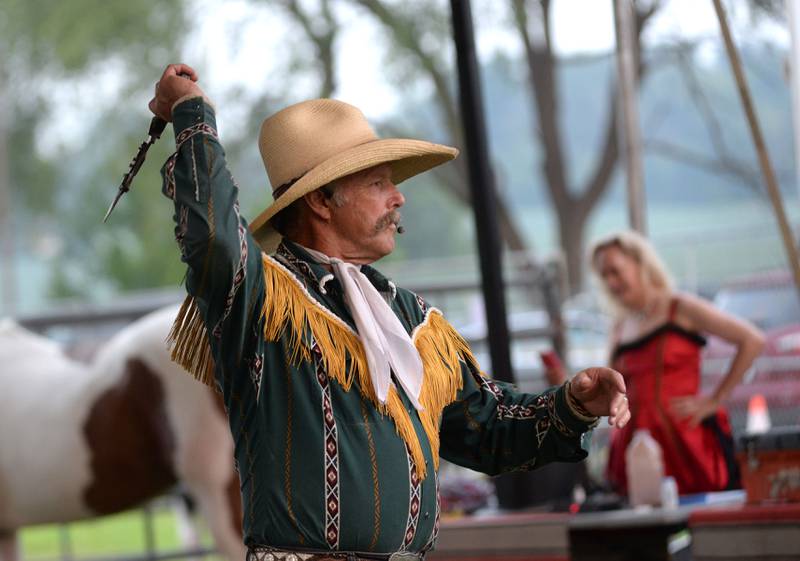 The Rhinestone Roper throws a bowie knife at a target during a performance at the Ogle County Fair in Oregon on Thursday, July 31, 2025.