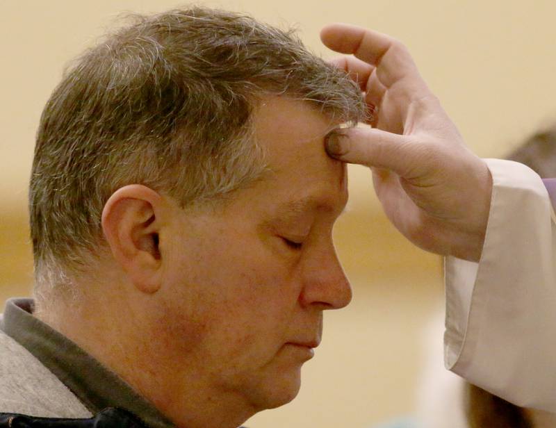 Dino Gualandri receives ashes on his forehead during the morning Ash Wednesday Mass from The Very Rev. Gary Blake on Wednesday, Feb. 22, 2023 at St. Valentines Church in Peru.