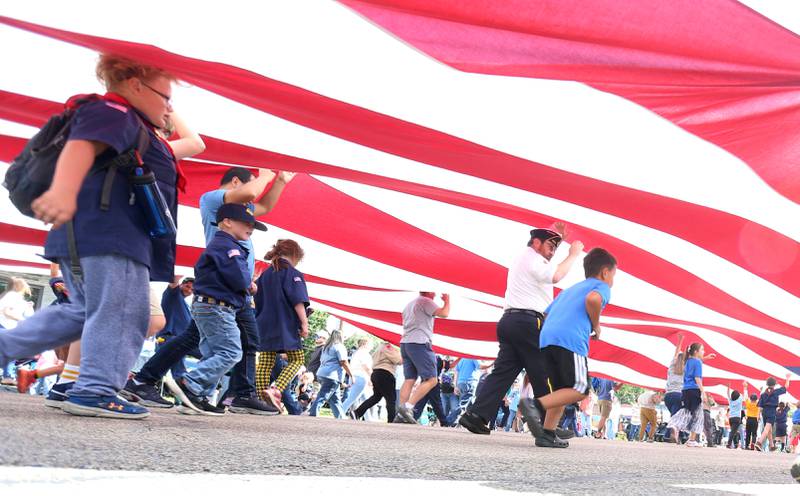 Boyscouts and Cubscouts carry a large American flag down South Main Street during the 54th annual Homestead Festival parade on Saturday, Sept. 6, 2025 in Princeton.