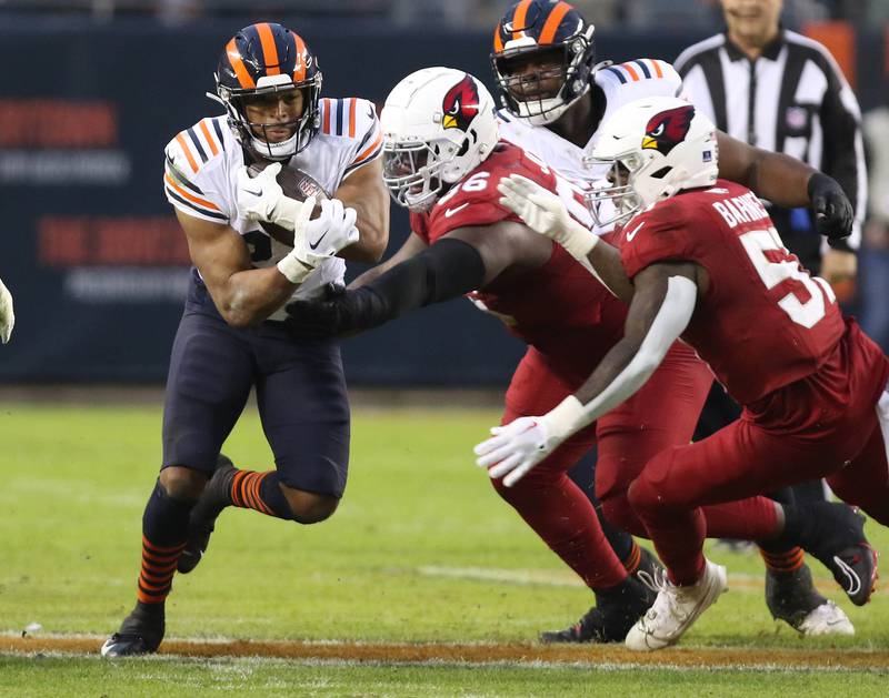 Chicago Bears running back Roschon Johnson runs by Arizona Cardinals defensive tackle Naquan Jones during their game Sunday, Dec. 24, 2023, at Soldier Field in Chicago.