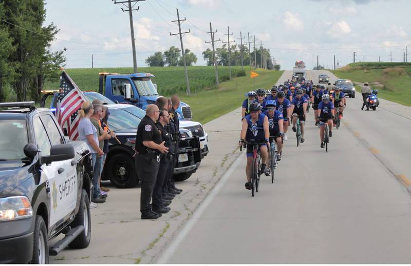DeKalb County Sheriff Andy Sullivan leads a group of cyclists as sheriff's deputies and onlookers line up along Illinois Route 23 to greet the nearly 100 cyclists biking from La Salle County to DeKalb on Saturday, July 12, 2025, for Cycle Across Illinois, a charity campaign to honor fallen police officers and raise funds for their families.