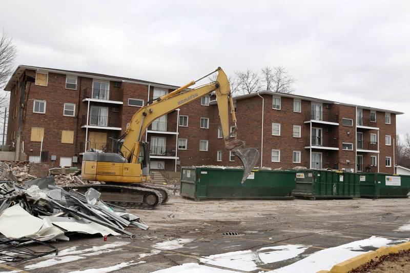 An excavator drives past what remains of the apartments at 1024 W. Hillcrest Drive in DeKalb after some of the building was torn down earlier in the day. The structure was ravaged by fire on Dec. 22, 2024, and condemned.