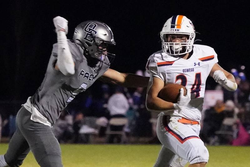 Oswego’s Ayden Villa (24) carries the ball against Oswego East's Jake Boissiere (9) during a football game at Oswego East High School on Friday, October 25, 2024.
