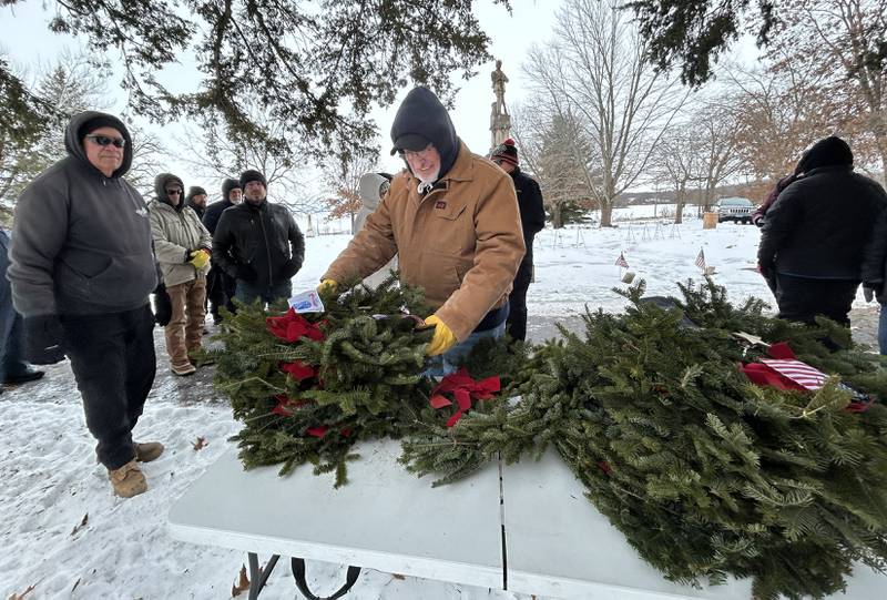 Veteran Don Stevens of Oregon picks up a wreath to be placed at the Civil War Veteran's Memorial to honor the United States Army at the Daysville Cemetery during the Wreaths Across America program on Saturday, Dec. 13, 2025.