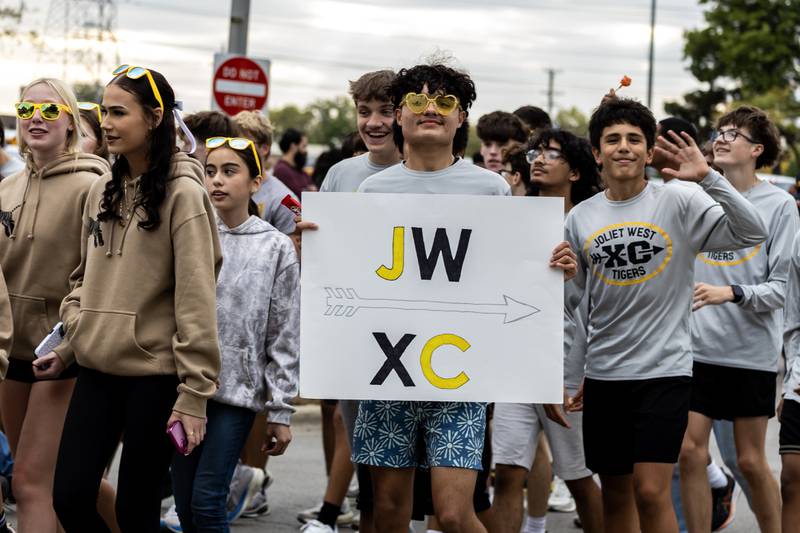 Members of the Joliet West cross country team walk along Glenwood Ave. in Joliet during the Joliet West homecoming parade on Oct. 10, 2025.